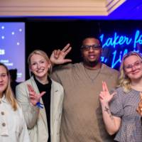 Grads anchor up in front of the Laker for a Lifetime sign
